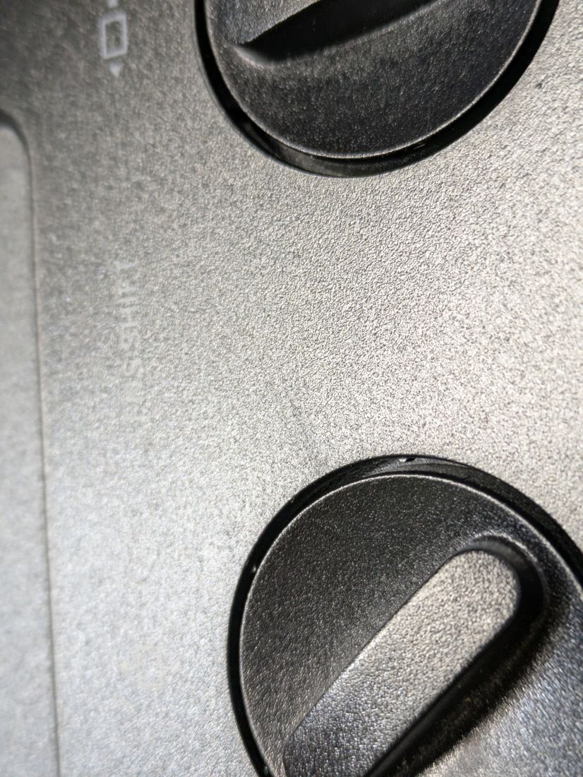 Macro of faint surface marks near the lens-shift dials