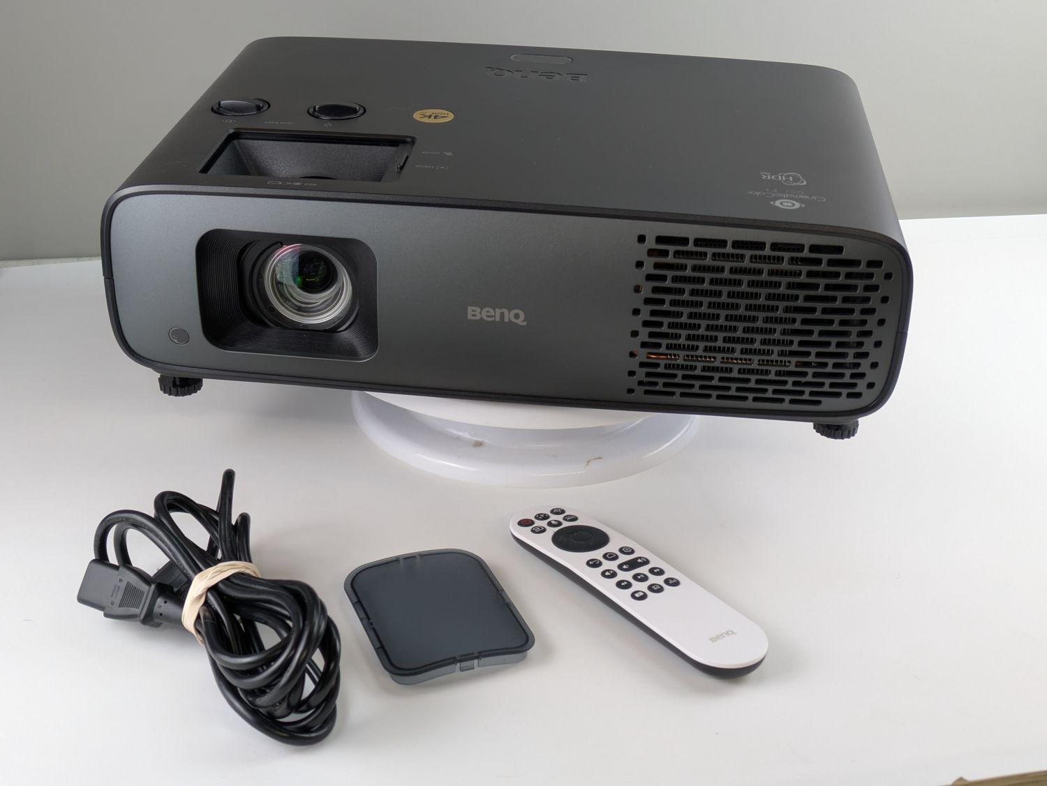 BenQ W4100i projector with its included remote and power cord on the inspection bench
