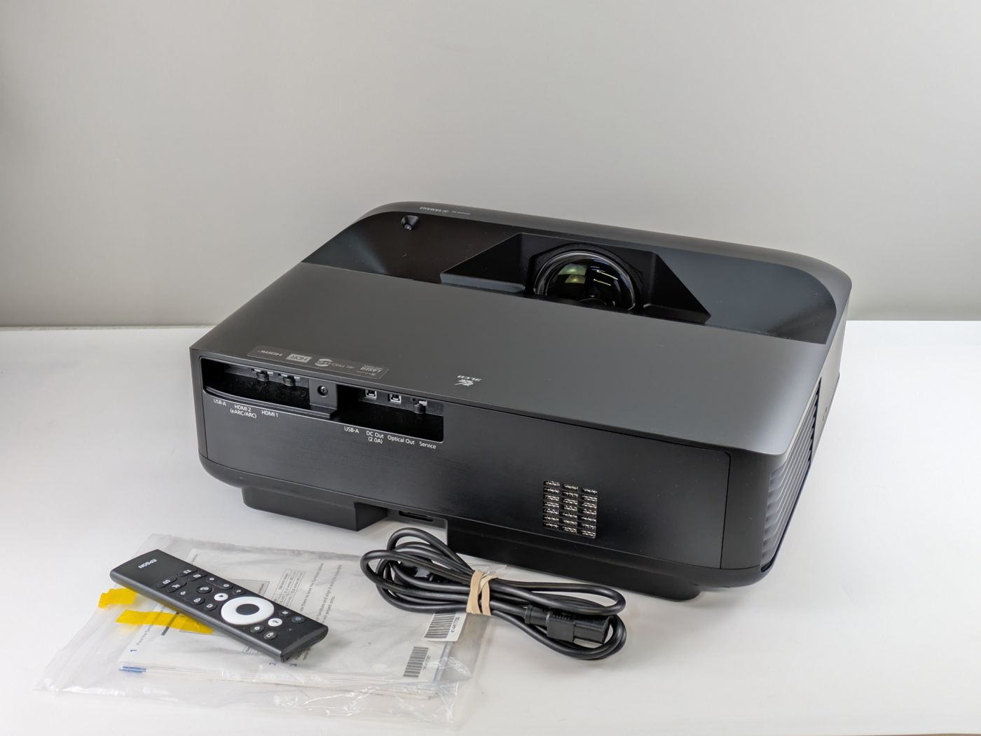 Epson EpiqVision Ultra LS650 ultra-short-throw projector as received, with remote and power cord
